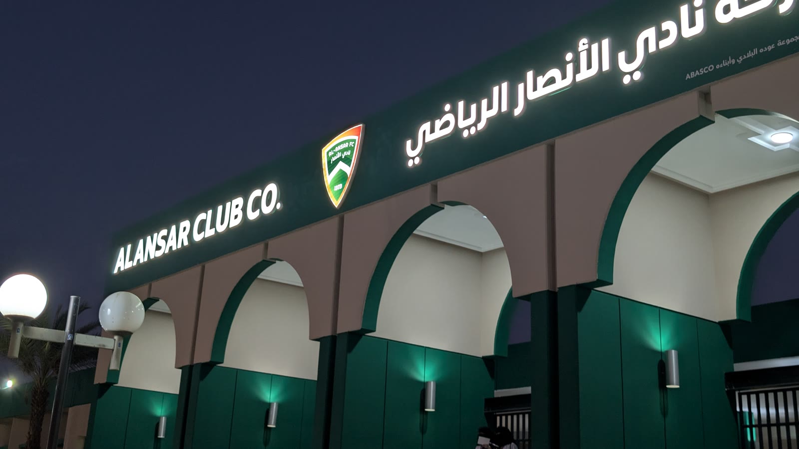 Al-Ansar Sports Club's illuminated entrance and signage in Madinah at night